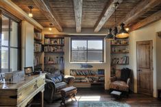 a living room filled with lots of furniture and bookshelves next to a window