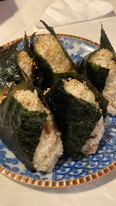 sushi on a blue and white plate with sesame seeds