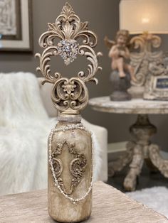 an ornate vase sitting on top of a table next to a white chair and lamp