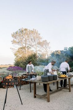 some people are cooking food on an outdoor grill