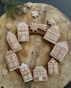 gingerbread cookies arranged in the shape of houses and stars on a piece of wood