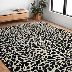 a black and white animal print rug in front of a window with a potted plant