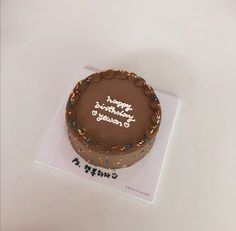 a chocolate birthday cake sitting on top of a card