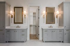 a bathroom with double sinks and two mirrors on the wall, along with marble flooring