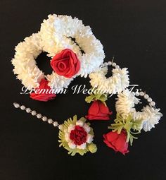 three red and white flowers are placed next to each other on a black surface with beads