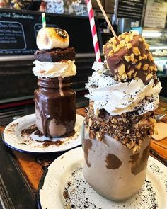 two desserts sitting on plates next to each other in front of a bakery counter