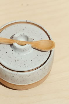 a wooden spoon in a ceramic container on a table