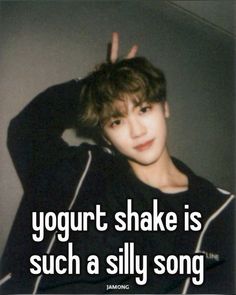 a young man with his hand up in the air and texting yogurt shake is such a silly song