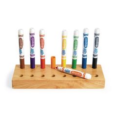 an assortment of crayons on a wooden holder