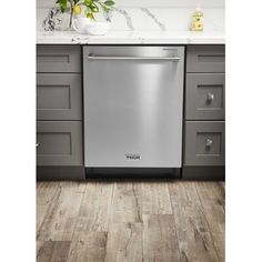 a stainless steel dishwasher sits in the middle of a kitchen with gray cabinets