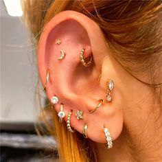 a woman wearing gold ear piercings with diamonds