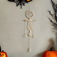 two pumpkins are sitting on the floor next to a wall with three halloween decorations