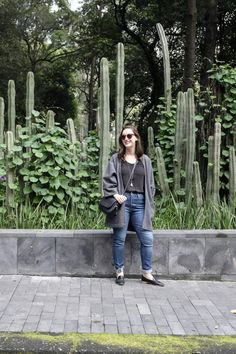 a woman standing in front of some cactus plants