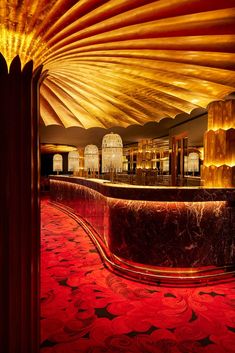 the interior of a bar with red carpeting and gold columns in front of it