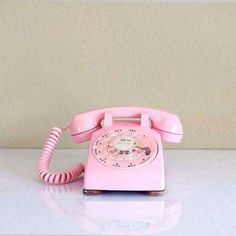 a pink phone sitting on top of a white counter