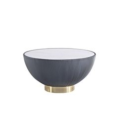 a black and white bowl sitting on top of a metal stand with a gold base