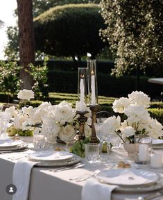 the table is set with white flowers and candles