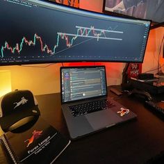 a laptop computer sitting on top of a wooden desk next to a monitor and mouse