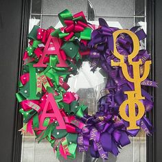 a colorful wreath with the word gay spelled in gold and purple ribbons on it's front door