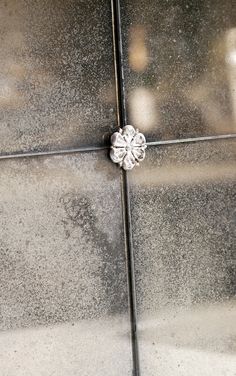 a close up view of the corner of a glass door with a flower on it