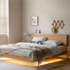 a bed sitting in a bedroom next to a window with blinds on the windowsill