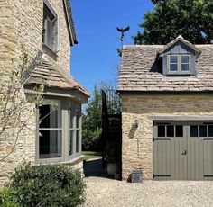 a stone building with two garage doors and windows