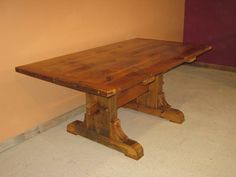 a wooden table sitting on top of a white floor next to a red and pink wall