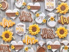 decorated cookies are arranged on a table with sunflowers and other things in the background