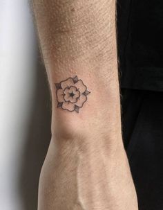 a small flower tattoo on the wrist