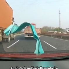 an obstructed blue ribbon is hanging from the side of a car's windshield