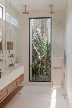 a bathroom with a sink, mirror and bathtub next to a large open window