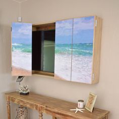 a wooden table sitting under a mirror next to a wall mounted painting on it's side