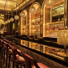 the bar is decorated in gold and black with chandeliers hanging from the ceiling