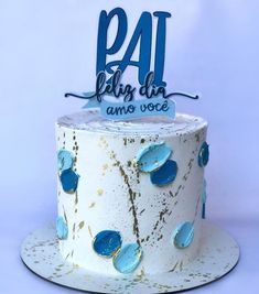 a white cake with blue frosting and gold sprinkles on the top