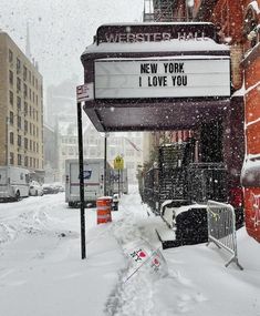 a sign that says new york i love you on the side of a building covered in snow