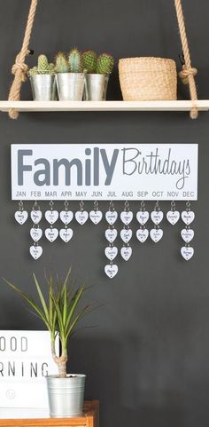 a family birthday sign hanging on a wall next to potted plants and a planter