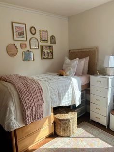 a bed room with a neatly made bed and lots of pictures on the wall above it