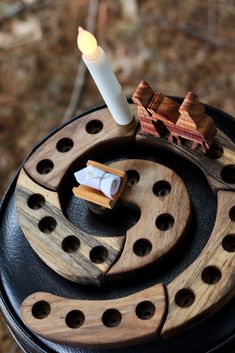 a candle is sitting on top of some sort of wooden object with holes in it