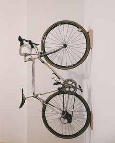 a bike hanging on the wall with it's front wheel still attached to the wall