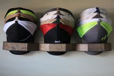 three hats are hanging on a wooden rack