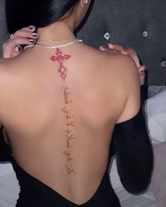 the back of a woman's body with writing on her upper and lower back