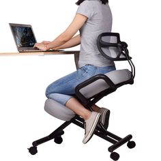 a woman sitting at a desk using a laptop computer