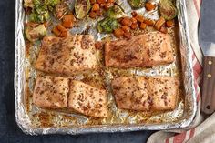 salmon and vegetables on a baking sheet ready to be cooked in the oven for dinner