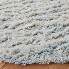 a blue and white rug on top of a wooden floor next to a hardwood floor