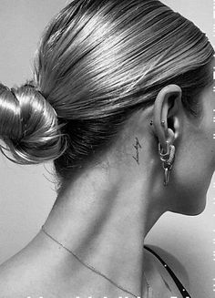 a woman with tattoos on her neck and behind her ear