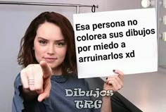 a woman holding up a sign that says, esa persona no colore su dibujos por medio a ar