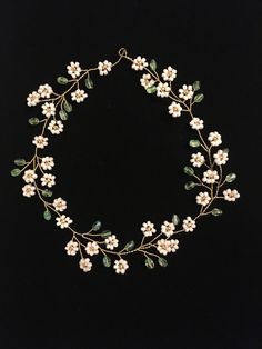 a white flower and leaf headband on a black background