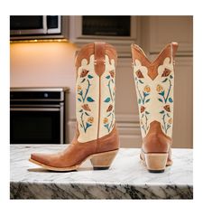 Idyllwind Women's Rosie Western Boots (Medium Sizes). This stylish boot features a tan leather upper with a snip toe design, making it perfect for dressing up or adding a touch of cowboy style to your everyday look. The pull tabs make it easy to slip on and off, while the leather upper provides a comfortable and breathable fit. The floral embroidery and inlay design on the shaft add a touch of whimsy and charm, making this boot a standout piece. The western heel gives the boot a classic cowboy s Western Cream Boots With Reinforced Heel, Cream Western Boots With Reinforced Heel, Western Style Cream Boots With Reinforced Heel, Western Cream Boots For Ranch, Cream Snip Toe Boots With Leather Sole, Cream Leather Heeled Boots With Snip Toe, Cream Leather Snip Toe Heeled Boots, Western Cream Snip Toe Heeled Boots, Western Beige Snip Toe Boots