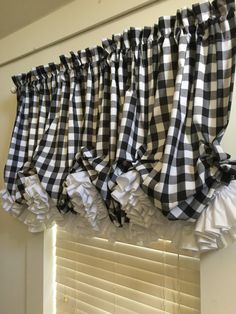 black and white checkered ruffled valance hanging on the window sill in front of an open window