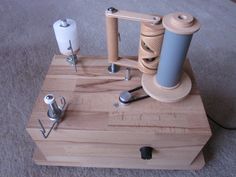 an assortment of sewing tools on a wooden block with thread spools and needles